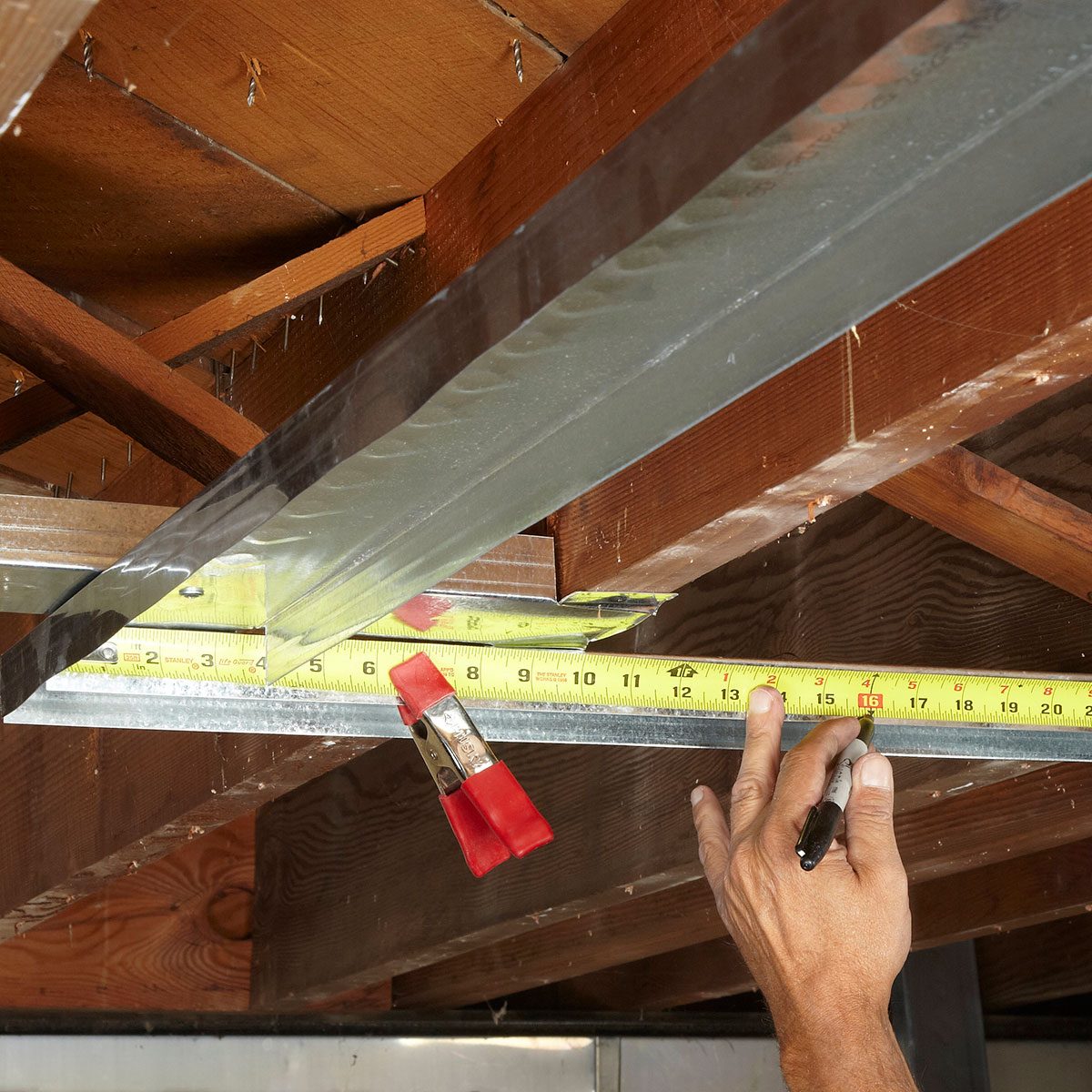 Lay out studs with a tape measure and a clamp | Construction Pro Tips