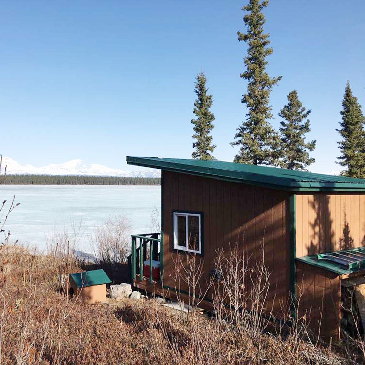 small cabin overlooking a lake and mountains in Alaska