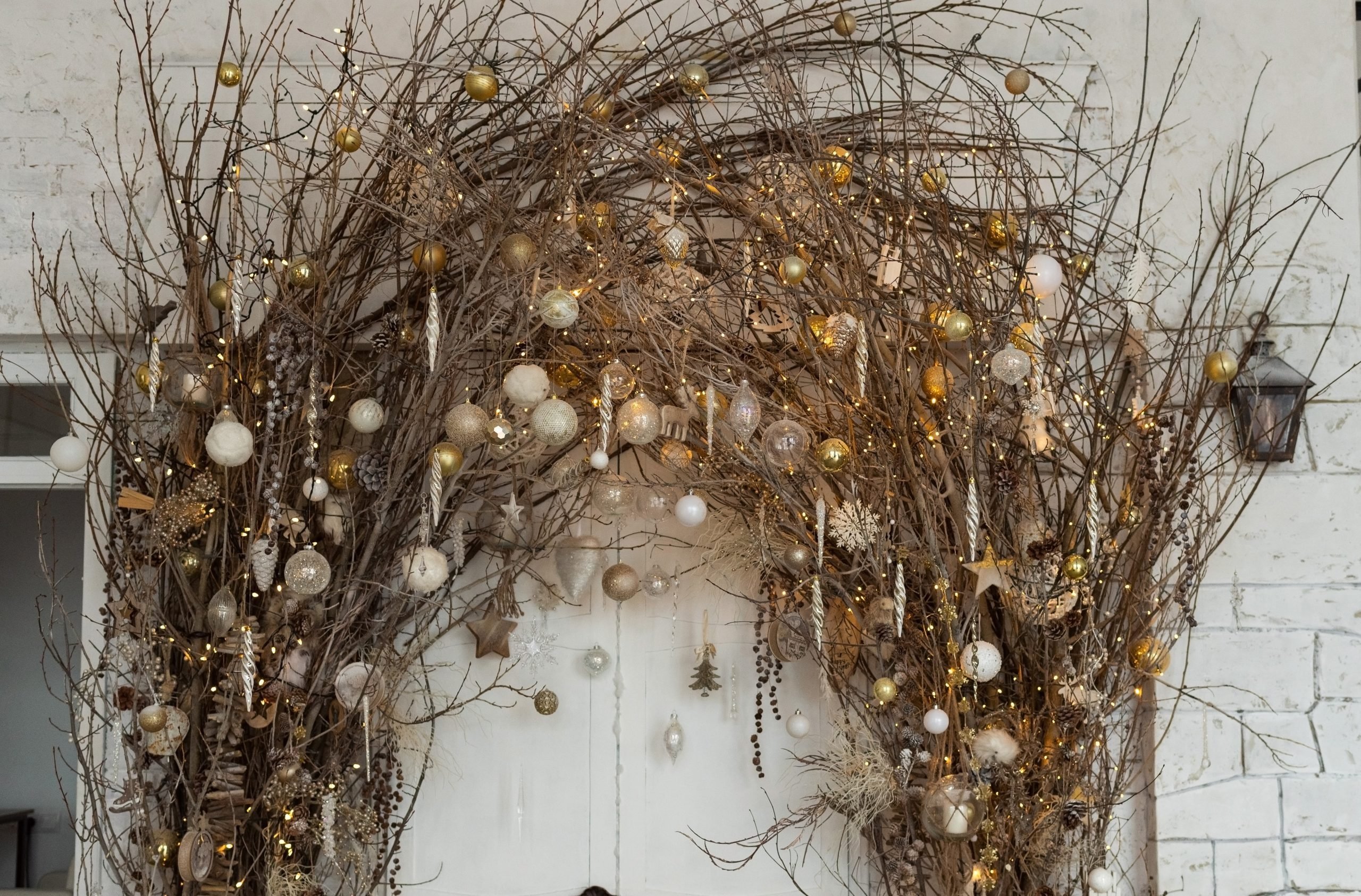 Christmas decorations with natural details: branches with garland lights and christmas balls. Eco decor in interior concept. Creative christmas tree.