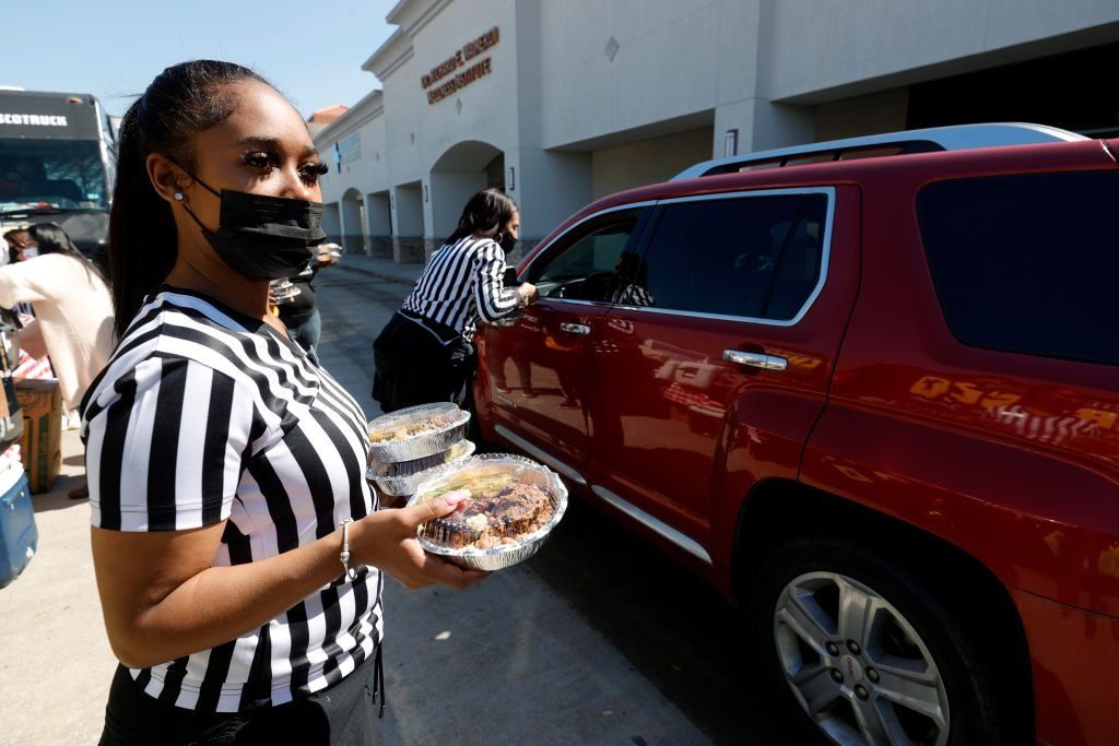 Volunteers pass out plates of food during a water distribution event at the Fountain Life Center on February 20, 2021 in Houston, Texas.