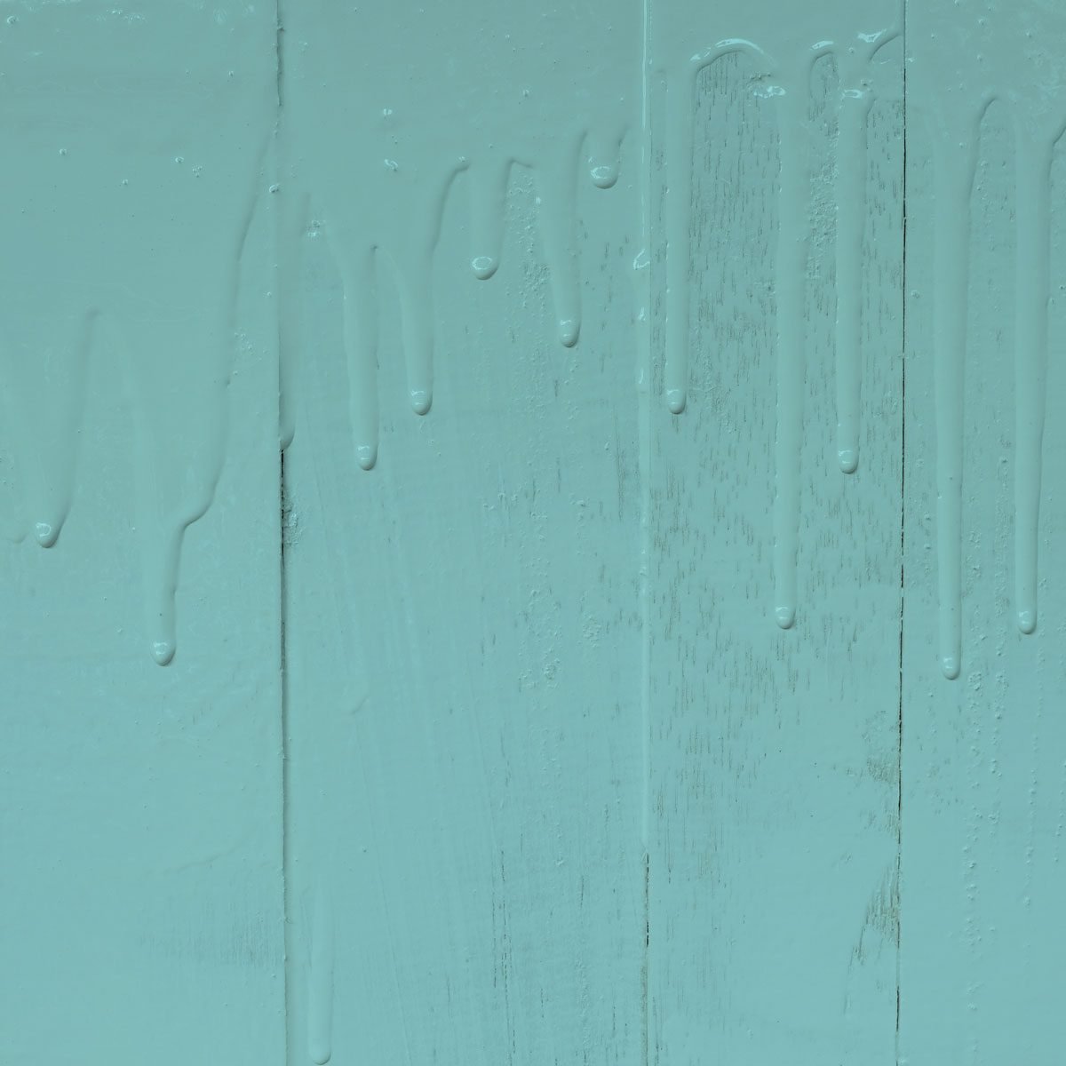 Dripping blue paint on highly textured wall