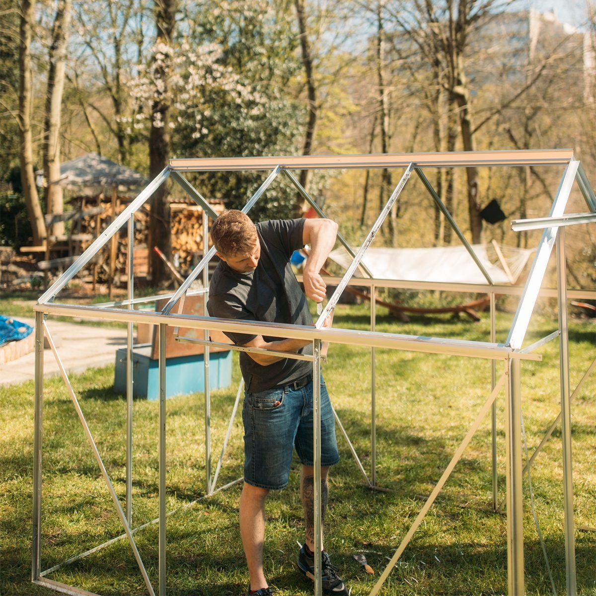 Gettyimages 1251808254 Man Building Greenhouse In Yard During Sunny Day Courtesy Westend61