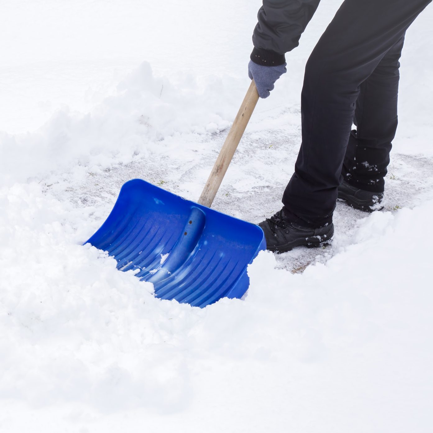 Man cleaning snow with shovel in winter day.