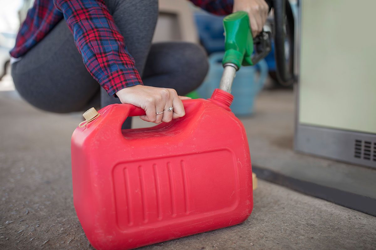 Woman Filling Up Gas Canister At Fuel Station