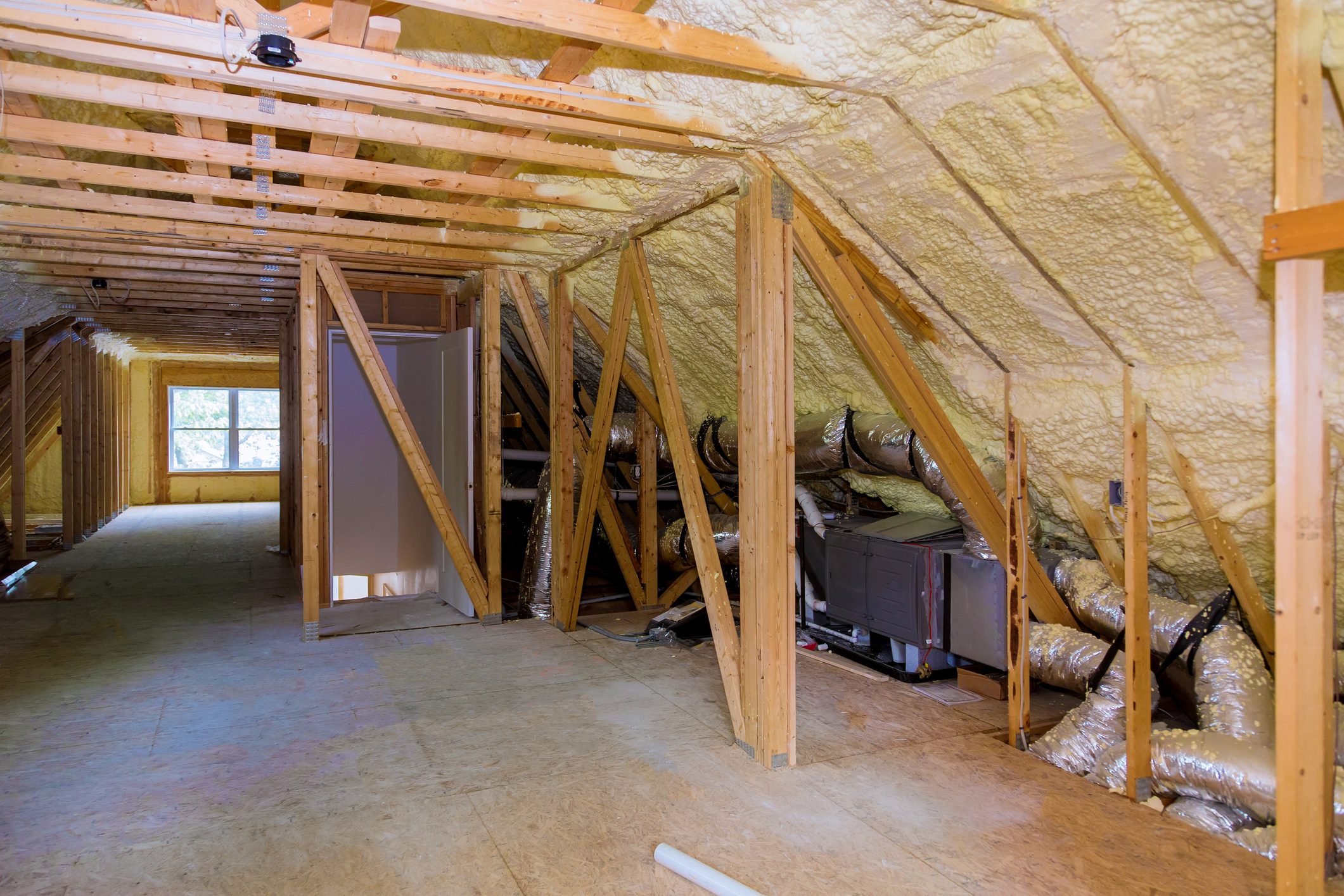 Foam plastic insulation installed in the sloping attic of new frame house.