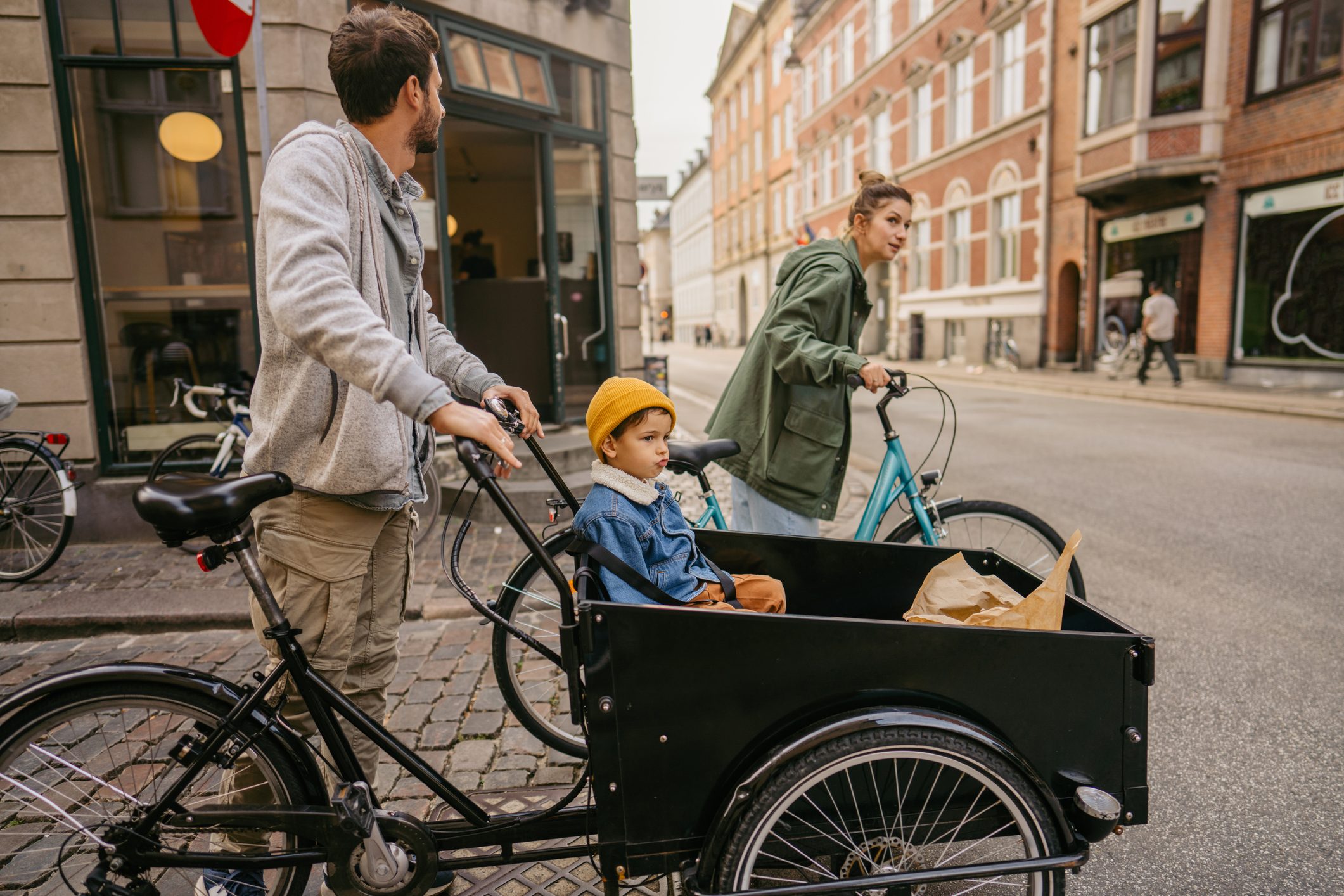 Photo of a young family running errands around the city on their bikes.