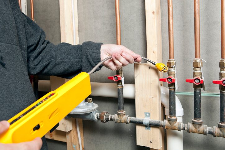 Worker Using a Leak Detector near House Gas Lines