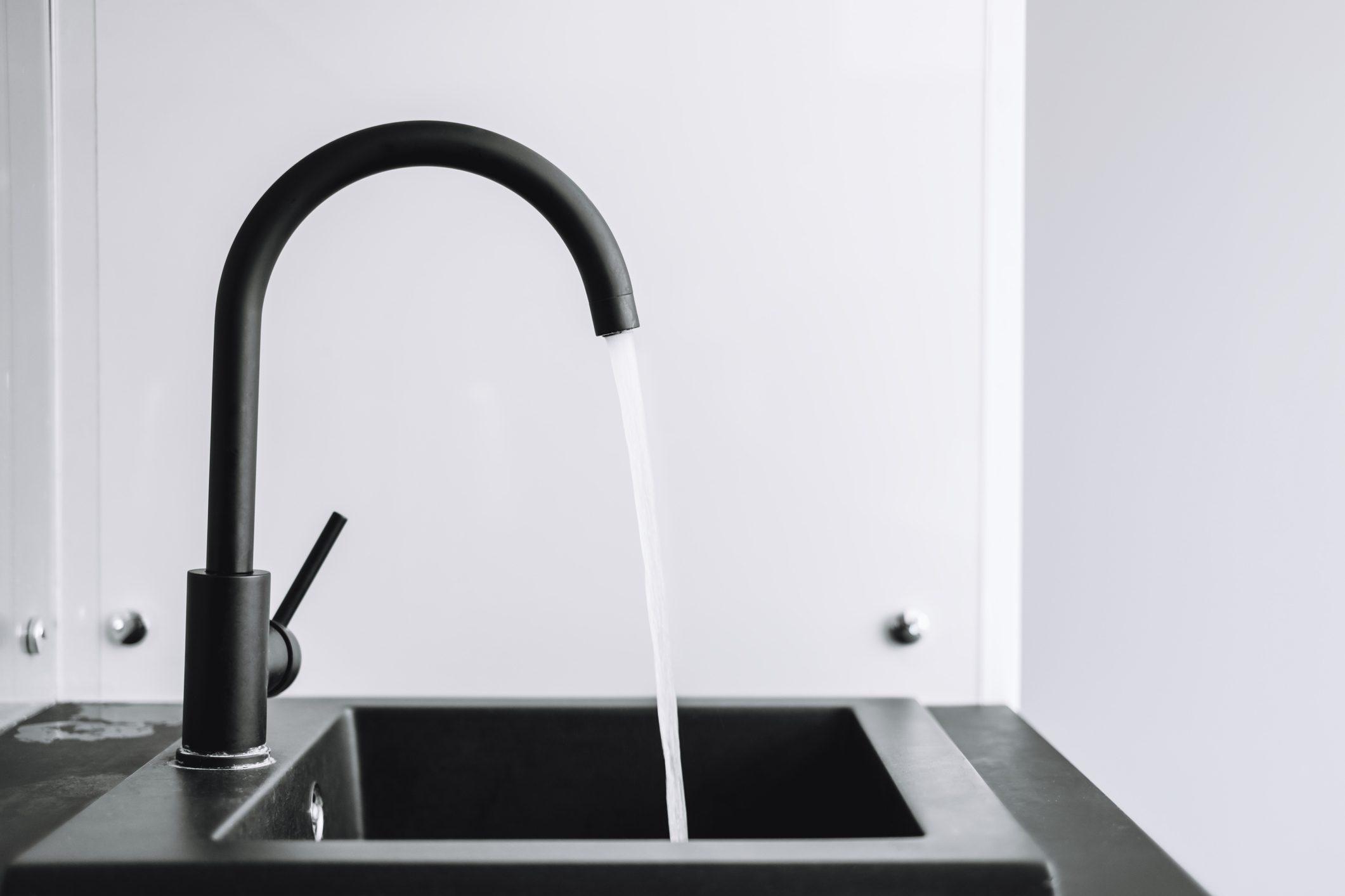 A running tap with the water running in the kitchen. The tap lets the water run.