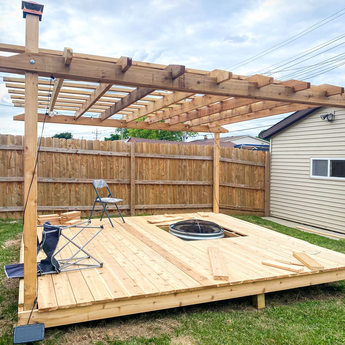 A backyard with a wooden deck and fire pit