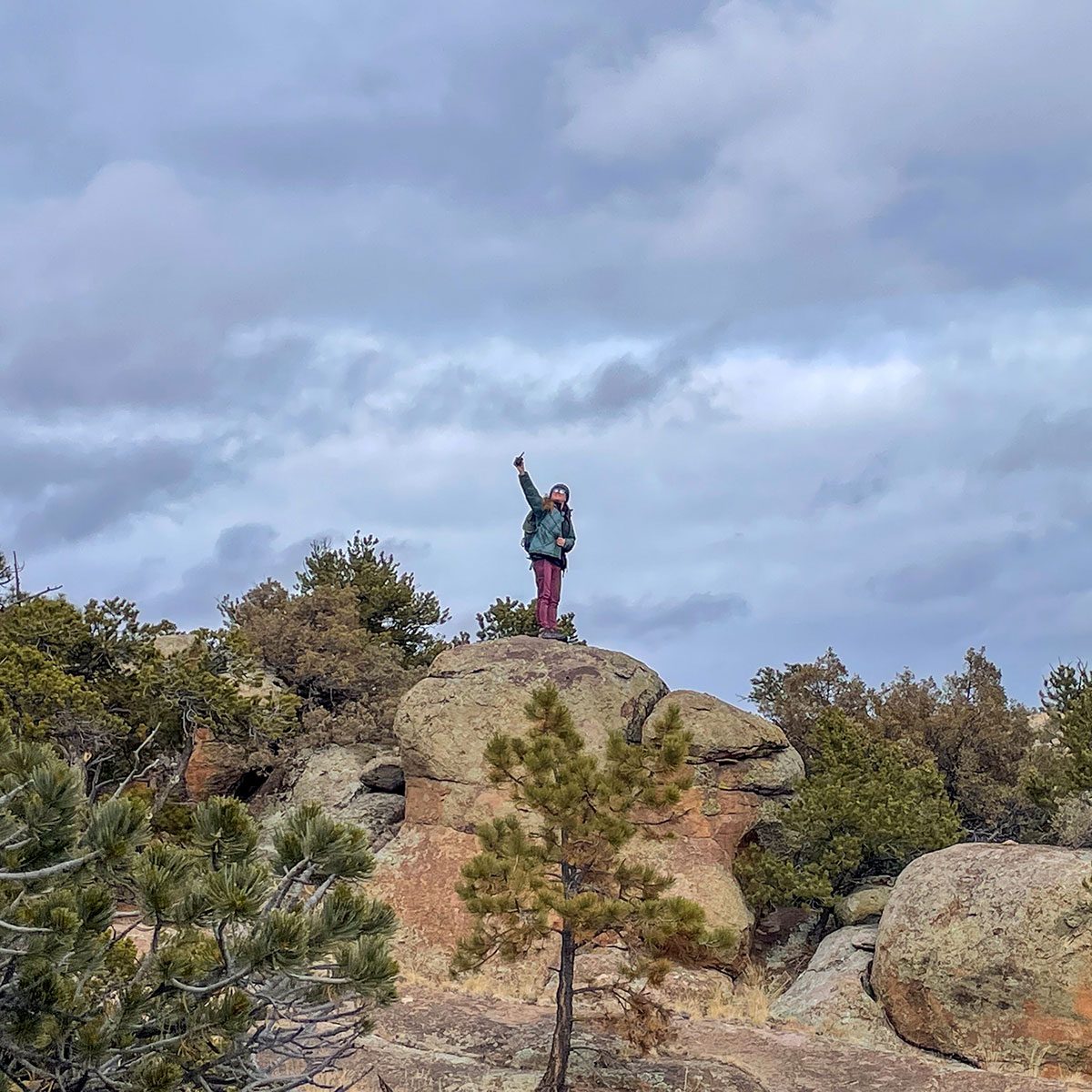 Woman holding Rocky Talkie Rugged Two Way Radio on top of mountain