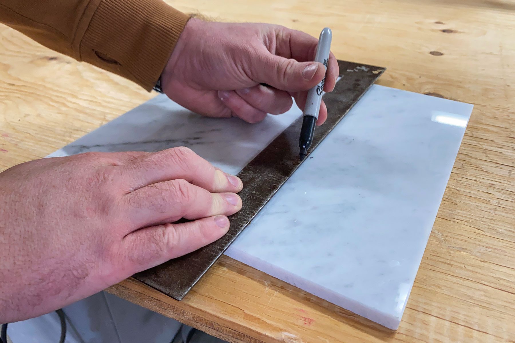 Measuring and marking the marble with scale and marker