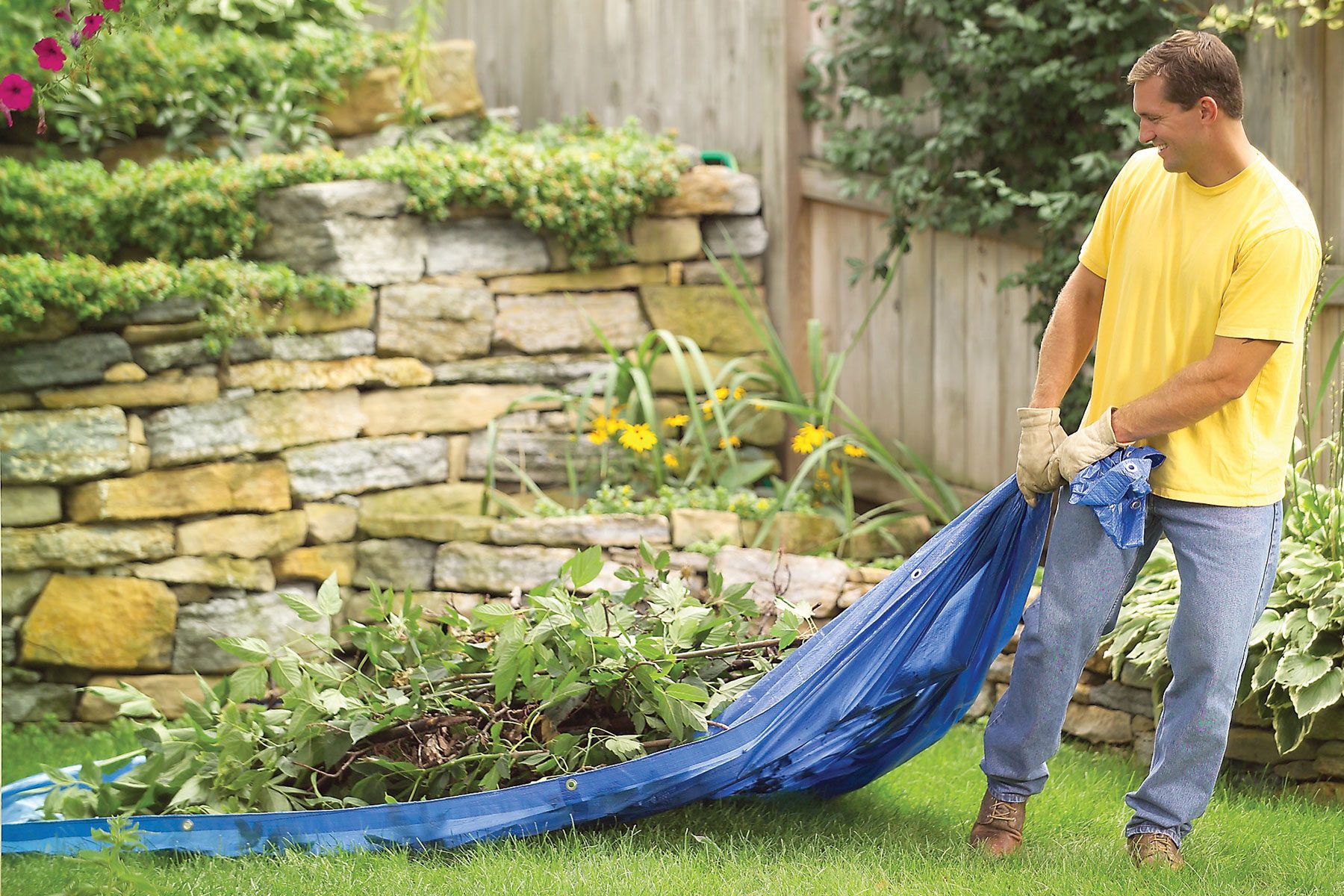 Man pulling tarpaulin sheet with plants 