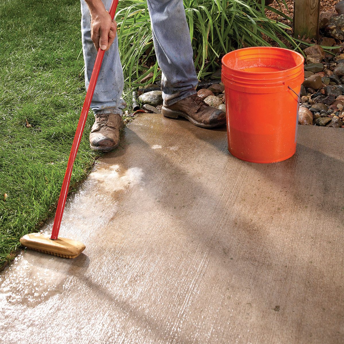 Man scrubbing the concrete ground