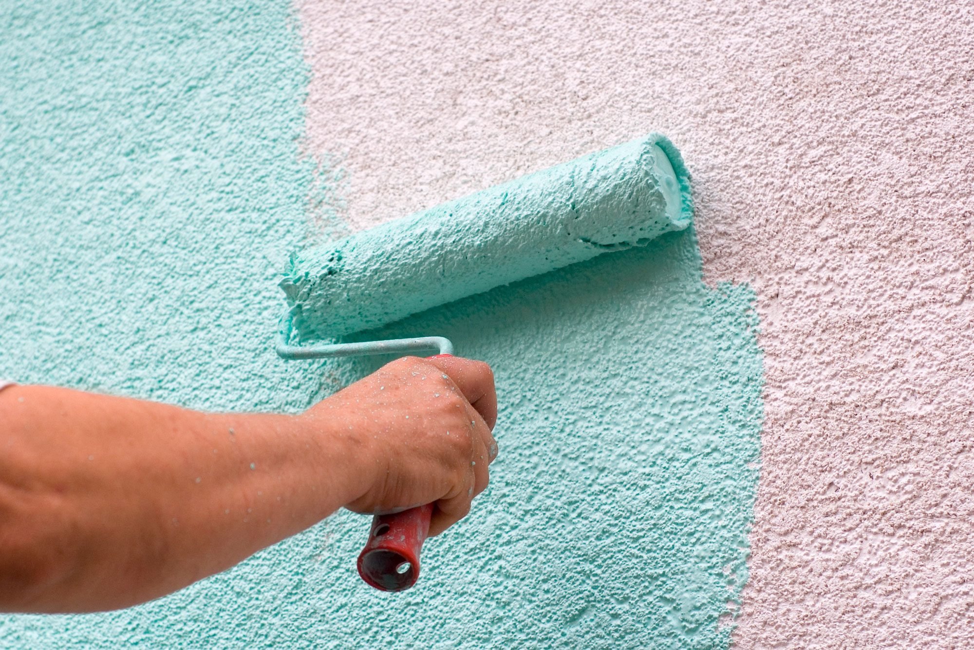 Male Worker Painting A Stucco Wall