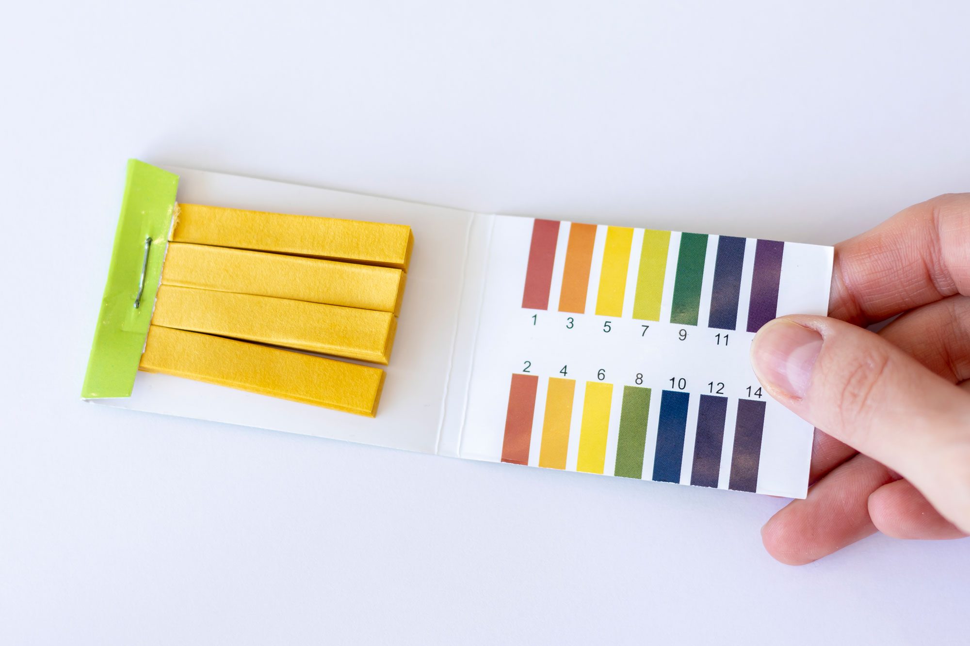 Test Strips To Measure Ph On A White Background In A Womans Hand