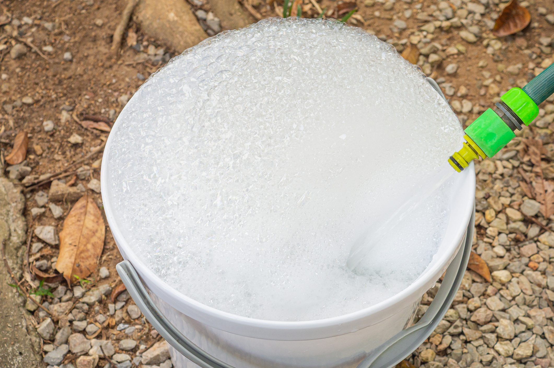 Close-up of bubbles water in a plastic bucket from a water hose