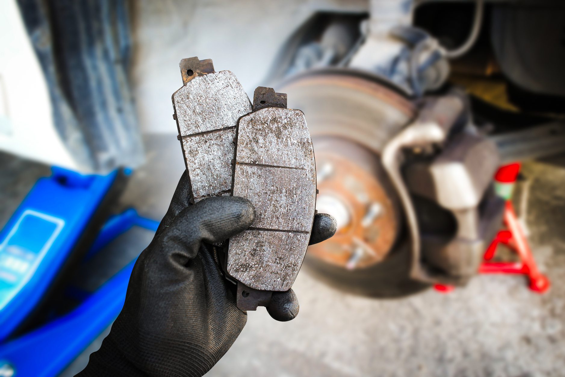 Used car brake pads in the hands of a mechanic
