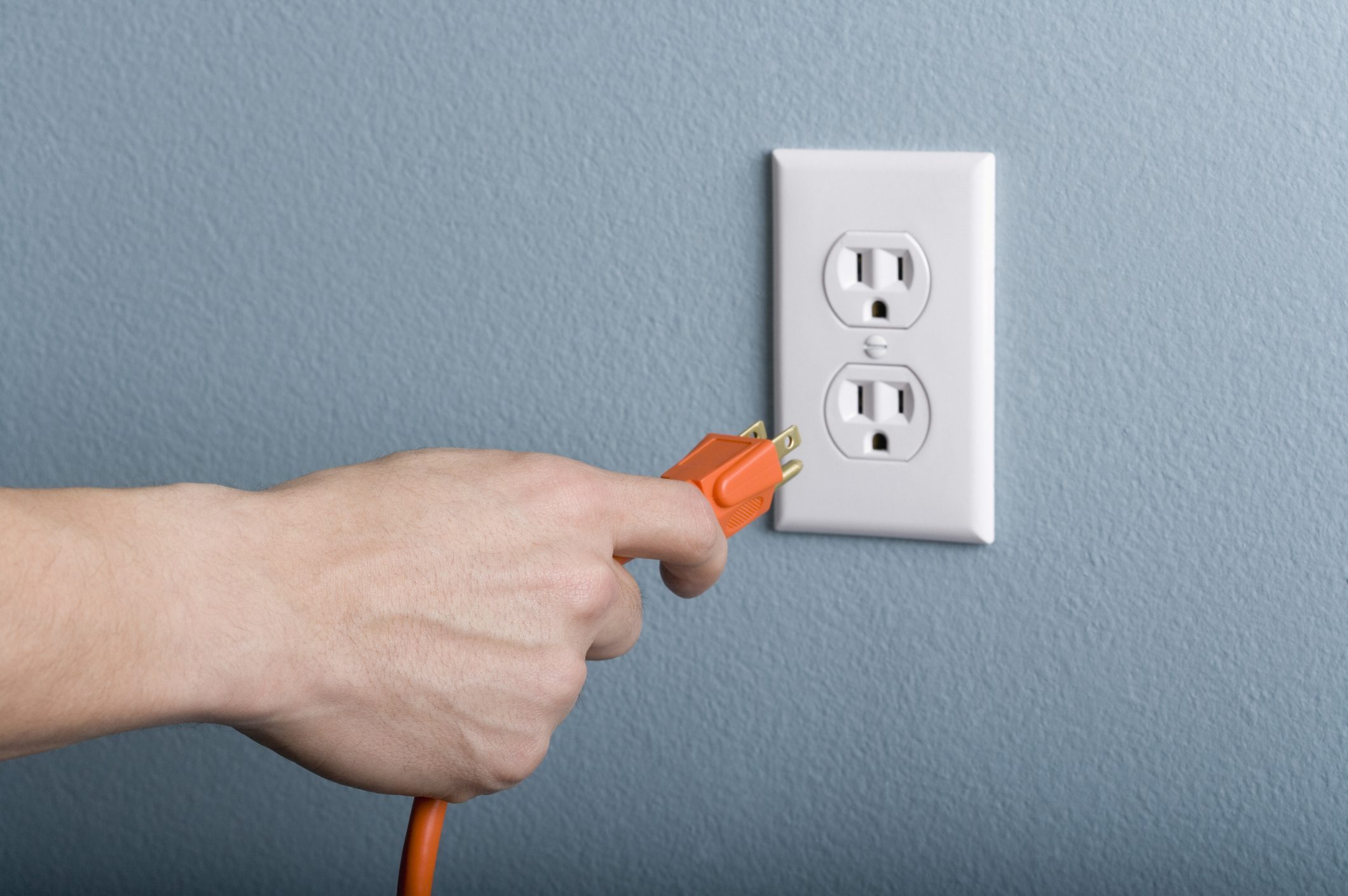 Hand plugging power cord into outlet