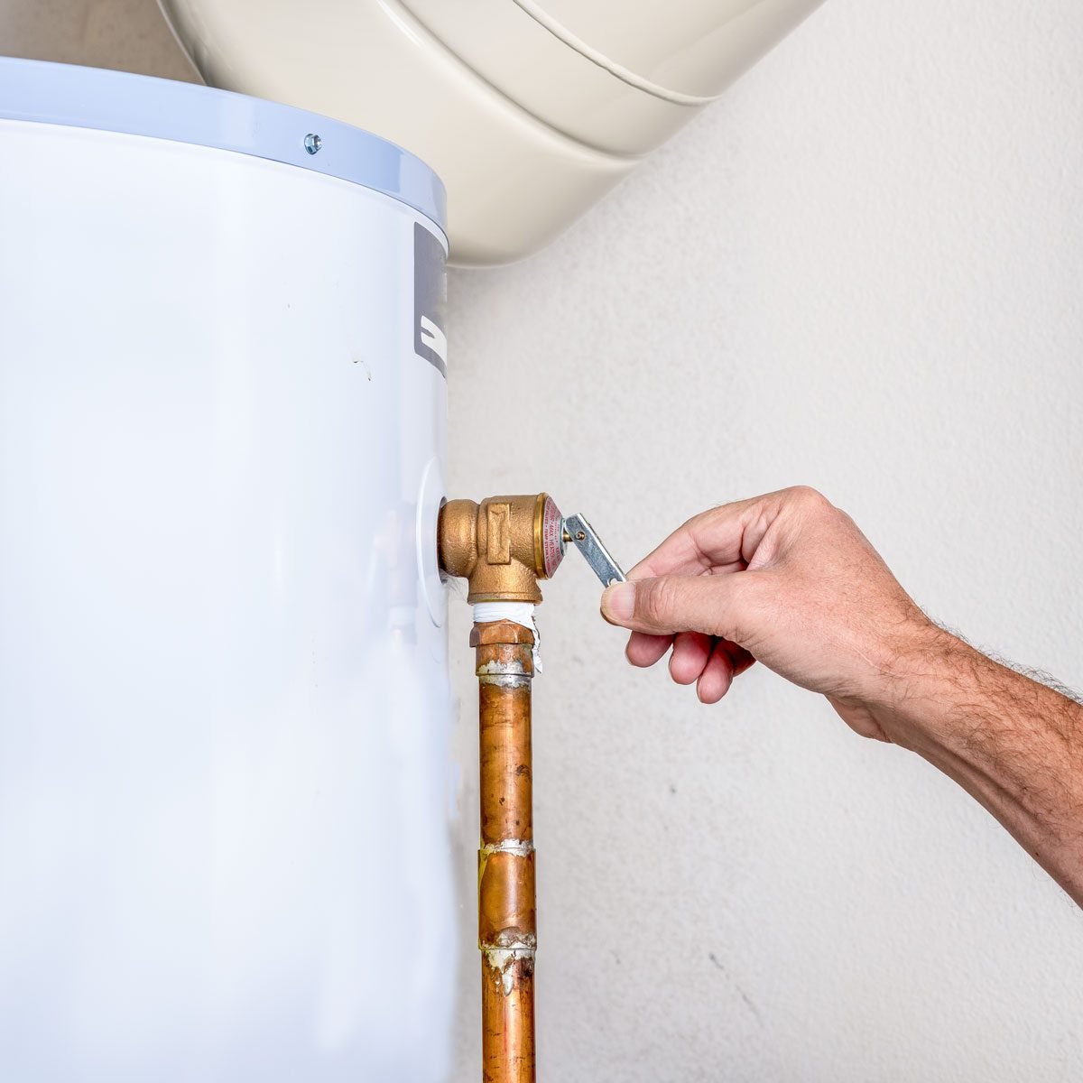 Mans Hand Tugs On The Pressure Relief Valve On A Hot Water Heater
