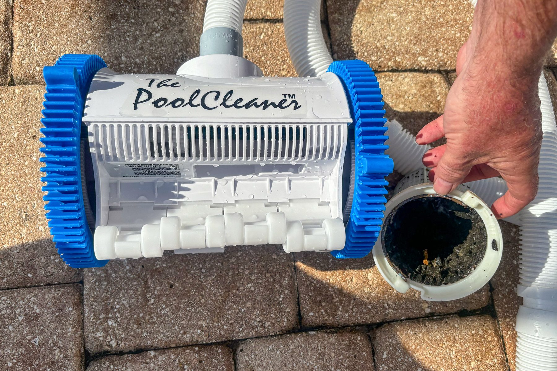 Hayward Pool Cleaner with a hand next to it holding a filter.