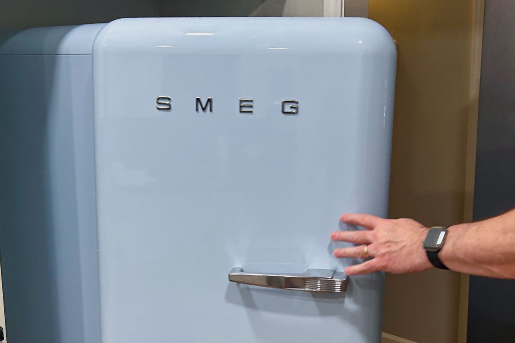 Hand can be seen opening the Smeg Fab 28 Fridge