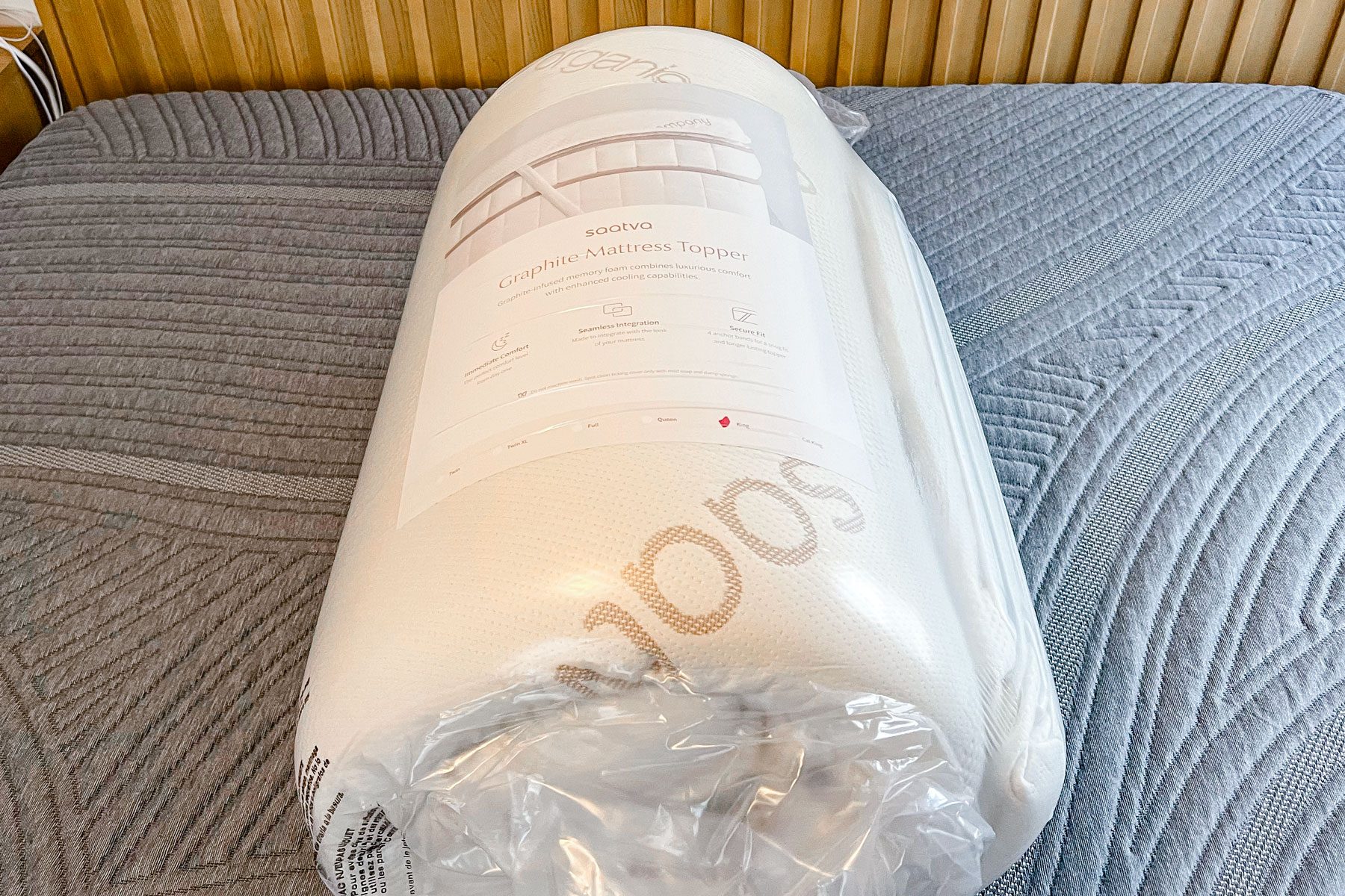 Compressed and rolled Saatva Graphite Memory Foam Mattress out of the packaging box.